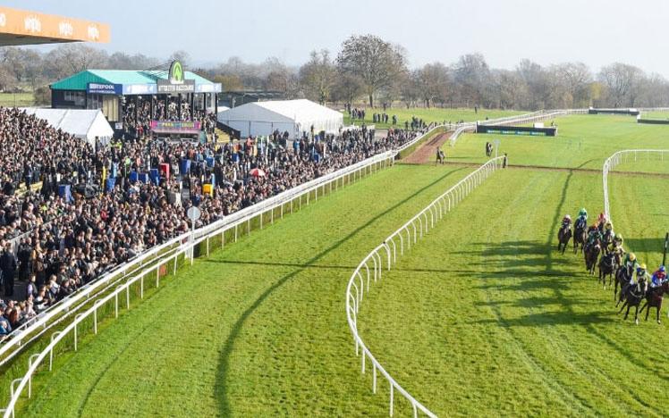 Crowds gathered at Uttoxeter Racecourse watching racing action on the track.