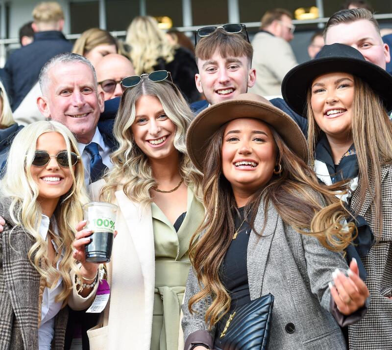 A group of racegoers in coats and hats at Uttoxeter Racecourse