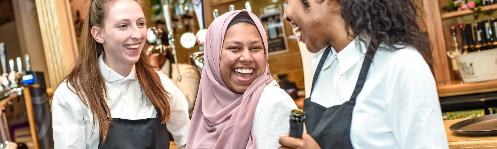 Three members of bar staff at Uttoxeter races share a laugh