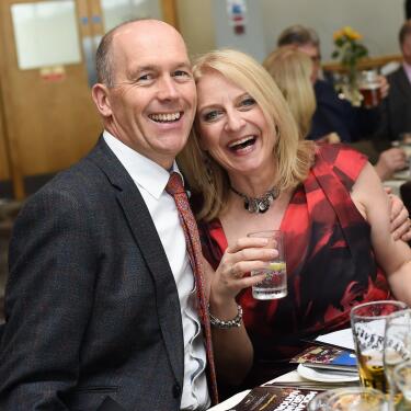 A happy, smiling couple at a restaurant table at Uttoxeter Races.