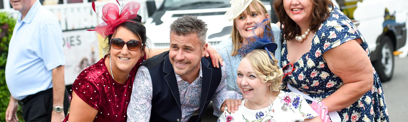 A group of racegoers at Uttoxeter pose in front of an ice cream van