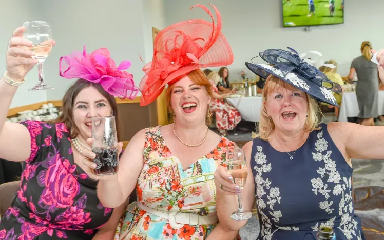 A group of hospitality guests at Uttoxeter cheer with their glasses
