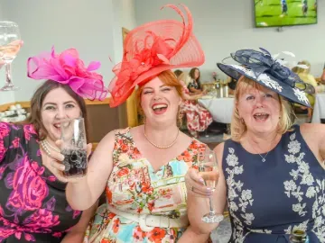 A group of hospitality guests at Uttoxeter cheer with their glasses