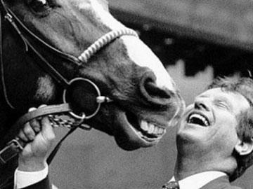 Charlie Lawson smiling posing for a photo with a horse.