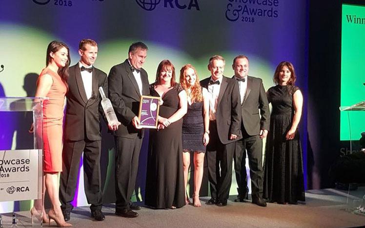 Members of the Uttoxeter Racecourse team standing on a stage, posing for a photo with an award.