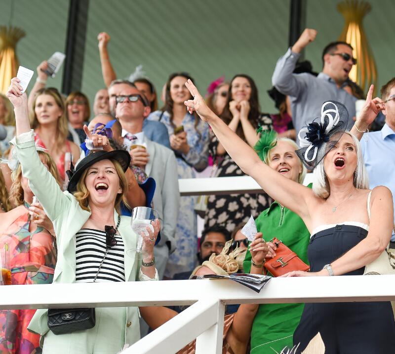 The crowd in the grandstand at Uttoxeter Races cheer and celebrate