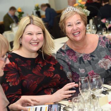 Two ladies smiling for the camera at their restaurant table
