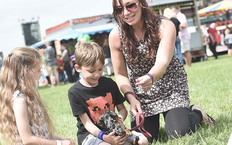 A family sitting down on the grass at Uttoxeter Racecourse.