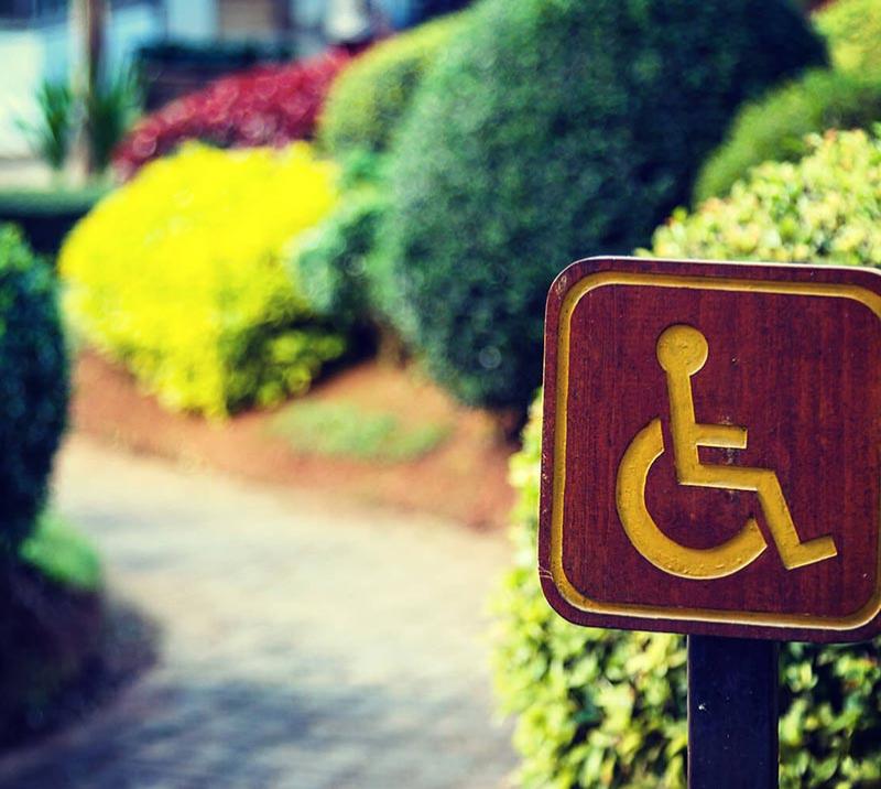 Disabled access signpost next to a path.