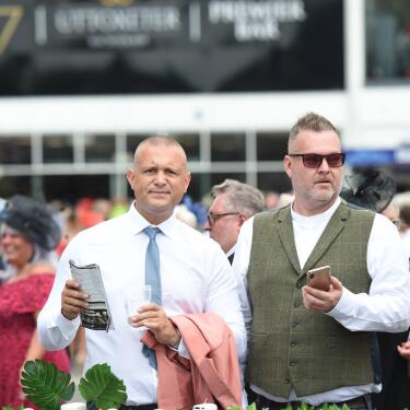 Two guys consulting their race card at phone at Uttoxeter Racecourse