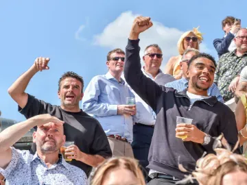 Some of the crowd at Uttoxeter Races cheering in the sunshine