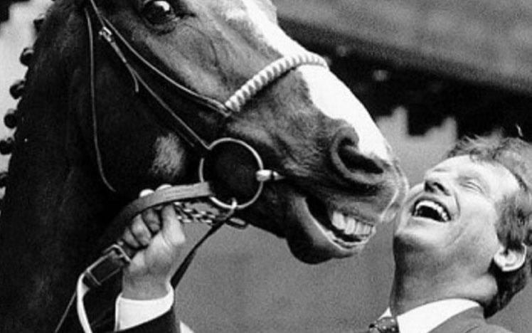 Charlie Lawson smiling posing for a photo with a horse.