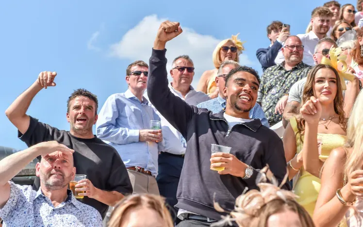Some of the crowd at Uttoxeter Races cheering in the sunshine