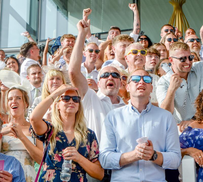 Part of the crowd in the grandstand at Uttoxeter reacting to the racing outcome