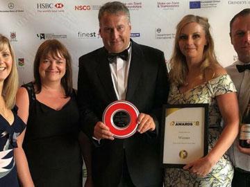 Members of the Uttoxeter Racecourse team posing for a photo holding awards in their hands.